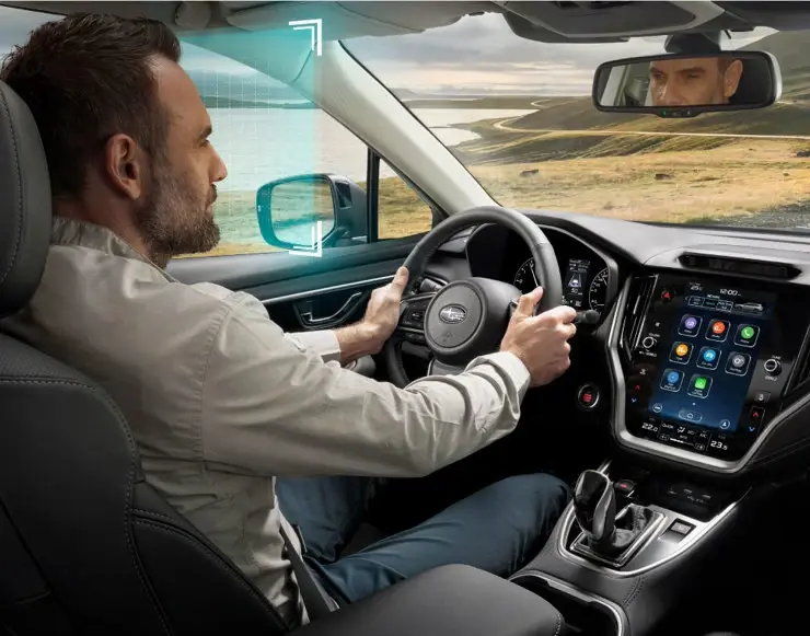 Hombre conduciendo auto Subaru con gesto de comodidad y tranquilidad.