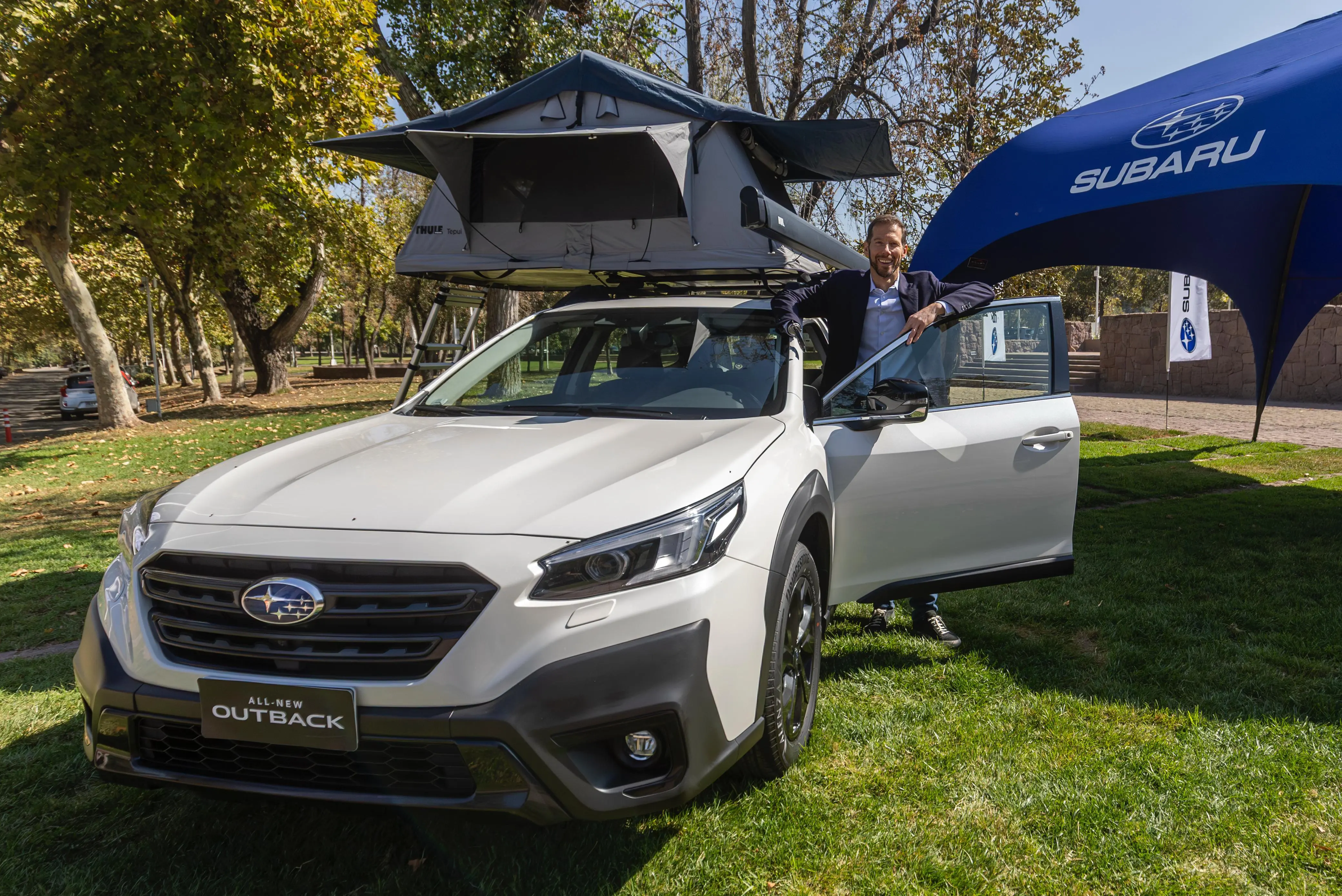 Subaru All New Ouback color blanco, estacionado en feria con las puertas abiertas