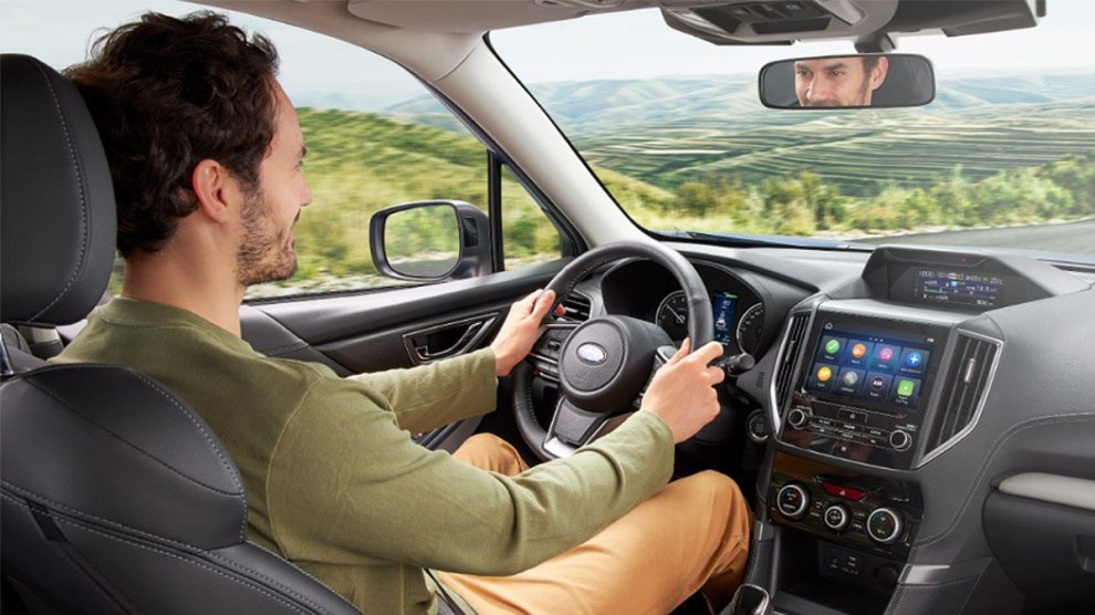 Hombre conduciendo en carretera un auto Subaru