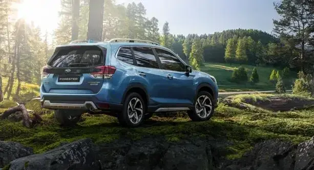 SUV híbrido modelo Forester con montañas y árboles de fondo