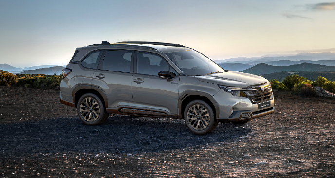 modelo Subaru Forester color verde en terreno arenoso con vegetación de fondo.