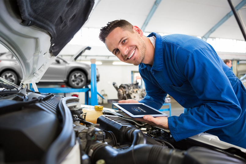 Mecánico frente realizando revisión a auto Subaru 